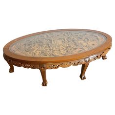 an oval wooden table with carvings on it