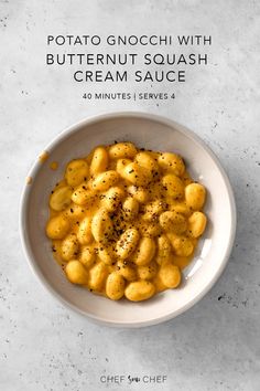 a white bowl filled with macaroni and cheese on top of a marble counter