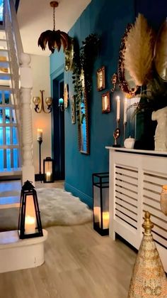 a living room filled with lots of furniture next to a stair case covered in candles