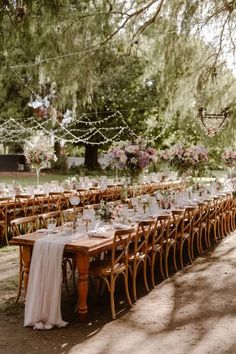 a long table is set up for an outdoor wedding