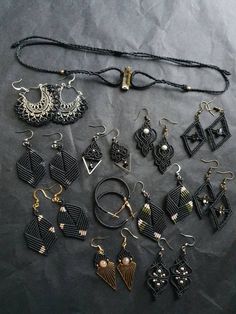 an assortment of earrings and necklaces on a black tablecloth background, top view