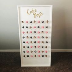 a cake pop board with pink and black frosted donuts on it's sides