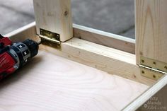 a driller is laying on the side of a wooden window sill with screwdrivers