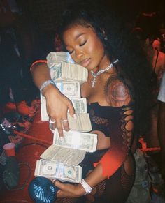 a woman holding stacks of money in her hands