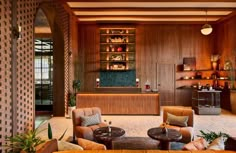 a living room filled with lots of furniture and wooden shelves next to a fire place