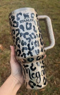 someone is holding up a coffee mug that has leopard print on it and the words, i'm stanley