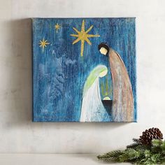 a painting of a manger scene on a wall next to a christmas tree and pine cones