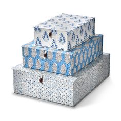 three boxes stacked on top of each other with blue and white designs in the middle