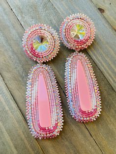 three pairs of pink and white beaded earrings on wooden floor with wood planks