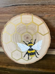 a bee painted on a piece of wood