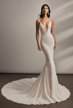 a woman in a white wedding dress with an open back and low neck, standing on a