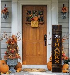 a front porch decorated for thanksgiving with pumpkins and gourds