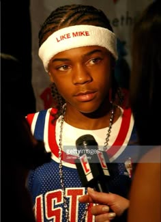 a young man with dreadlocks and a headband is interviewed at an event