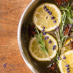 lemons, rosemary, and lavender in a pan on a wooden counter top with spices