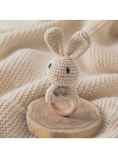 a crocheted bunny sitting on top of a wooden block