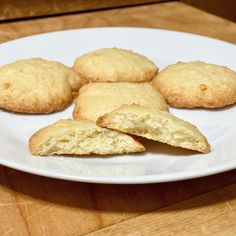 four biscuits on a white plate sitting on a wooden table