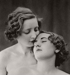 two women are embracing each other while one woman is holding her head to her chest