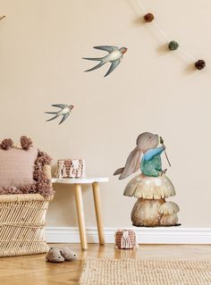 a room with some birds flying around the wall and decorations on the floor in front of it