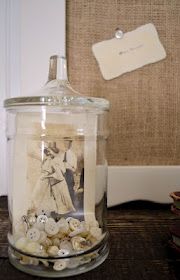 a glass jar filled with lots of buttons on top of a table