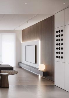 an empty room with white walls and wood accents on the wall, along with a round table