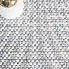 a blue and white rug next to a pair of scissors on top of a table