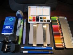 an assortment of art supplies including markers, pencils, and paintbrushes on a table