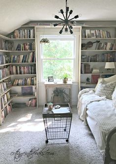 a living room with bookshelves and a couch in the corner, next to a coffee table