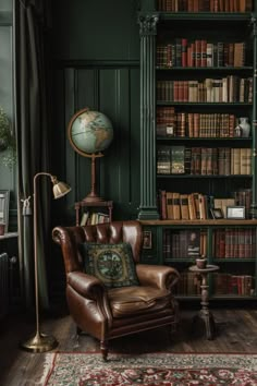 a chair in front of a bookshelf with a globe on top of it