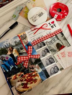 a table topped with pictures and other items next to a red pen on top of it