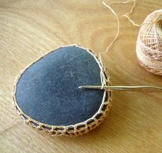 a pair of scissors sitting on top of a wooden table next to some yarn and twine