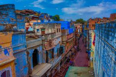 an aerial view of a city street with blue and yellow buildings in the background,