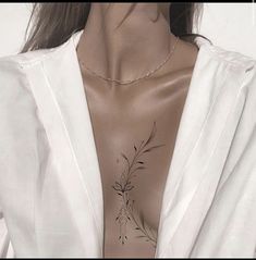 a woman with tattoos on her chest wearing a white shirt