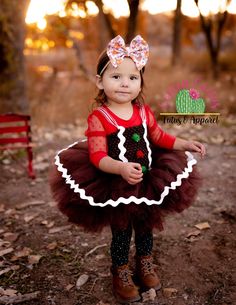 This adorable gingerbread tutu dress features brown glitter tulle and frosting! The straps are adjustable by tightening the bow in the back. Skirt length: 0-6 months is approximately 4 inches long. 6 mos - 2T is approximately 6 inches long. 3-4T is approximately 8 inches long. 5-6T is approximately 10 inches long.Skirt length: 3-9 months is approximately 4 inches long. 9-24 months is approximately 5 inches long. 3/4T is approximately 6 inches long. 5/6T is approximately 8 inches long. Cute Christmas Tutu Dress With Ruffles, Cute Fitted Christmas Tutu Dress, Cute Fitted Tutu Dress For Christmas, Cute Christmas Tutu Dress, Cute Fitted Tutu Dress For Festive Occasions, Cute Fitted Tutu Dress For Festivities, Fitted Tulle Tutu Dress For Holiday, Gingerbread Costume, Christmas Pageant