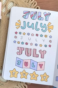 an open notebook with the words july and stars on it next to some crayon markers