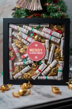 a box filled with christmas candy next to gold candies and other holiday decorations in front of a christmas tree