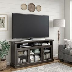 a large flat screen tv mounted to the side of a wooden entertainment center in a living room