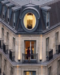 two people standing on the balcony of an apartment building