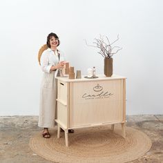 a woman standing next to a wooden cabinet