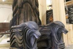 a statue of a dog laying on top of a wooden bench in front of a tall column