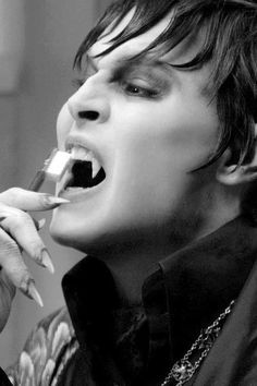 a woman brushing her teeth with an electric toothbrush