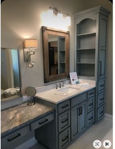 a bathroom with two sinks and a large mirror on the wall above it's cabinets