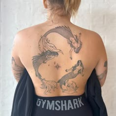 the back of a woman's body with tattoos on her upper and lower back