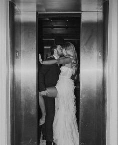 a man and woman kissing in an elevator