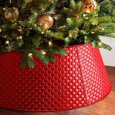 a christmas tree in a red basket on the floor