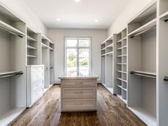 an empty walk - in closet with lots of shelves and drawers on the floor,