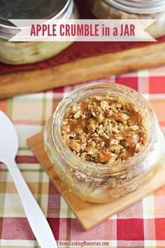 an apple crumble in a jar on top of a cutting board