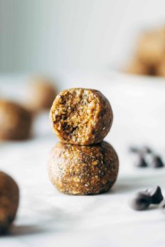 two cookies stacked on top of each other with raisins scattered around them and one cookie in the foreground