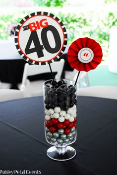 a vase filled with candies and lollipops on top of a table