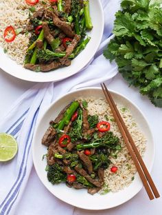 two white plates filled with stir fry beef and broccoli on top of rice