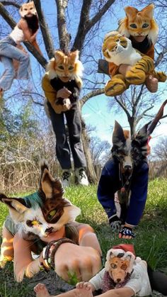 several stuffed animals sitting on the ground in front of some trees and one is holding a cat